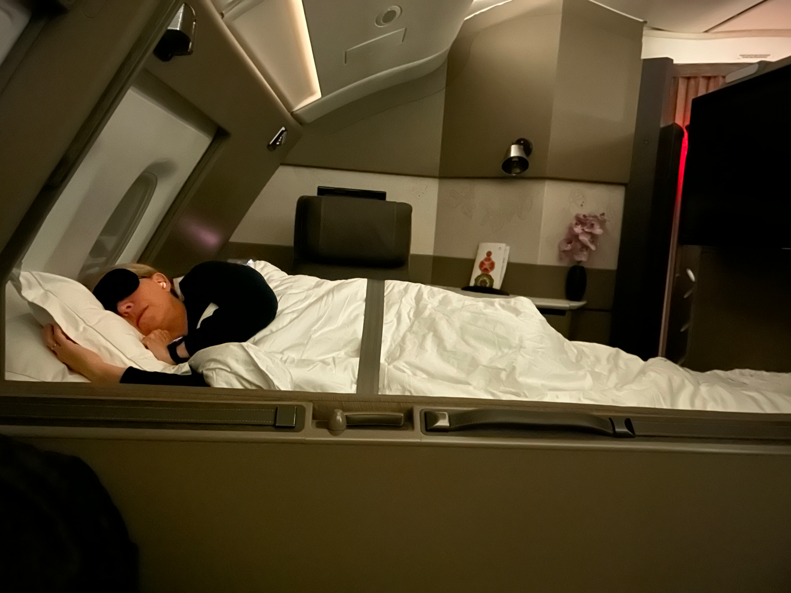 Shawn sleeping in her bed on the plane