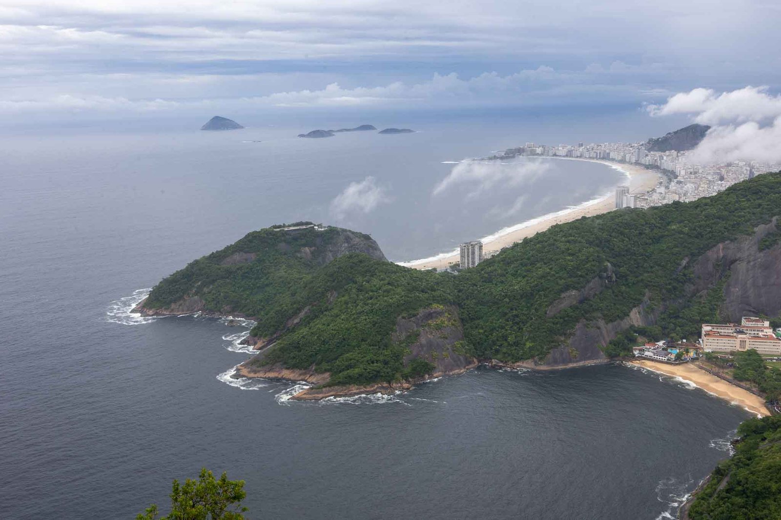 Copacabana in the distance the red sand beach in the foreground.